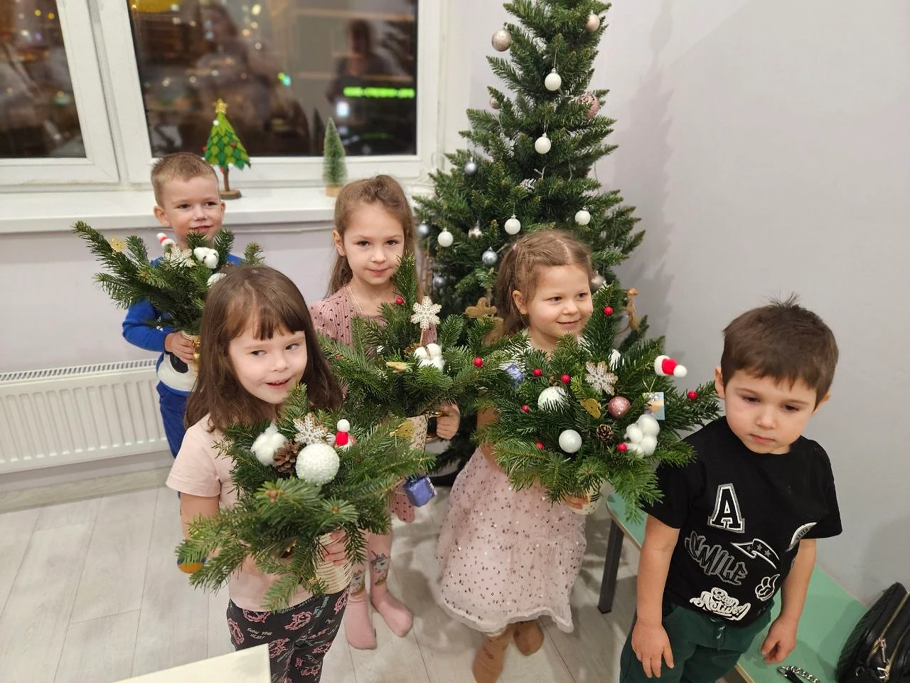 Дети показывают новогодние композиции из еловых веток